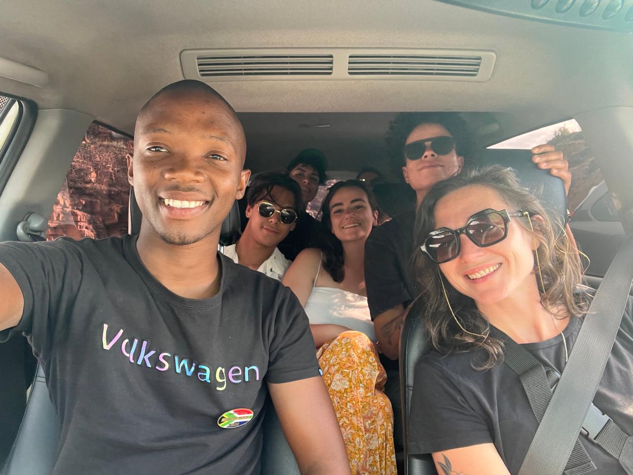 Tour guide and smiling guests packed into the SL Tours vehicle