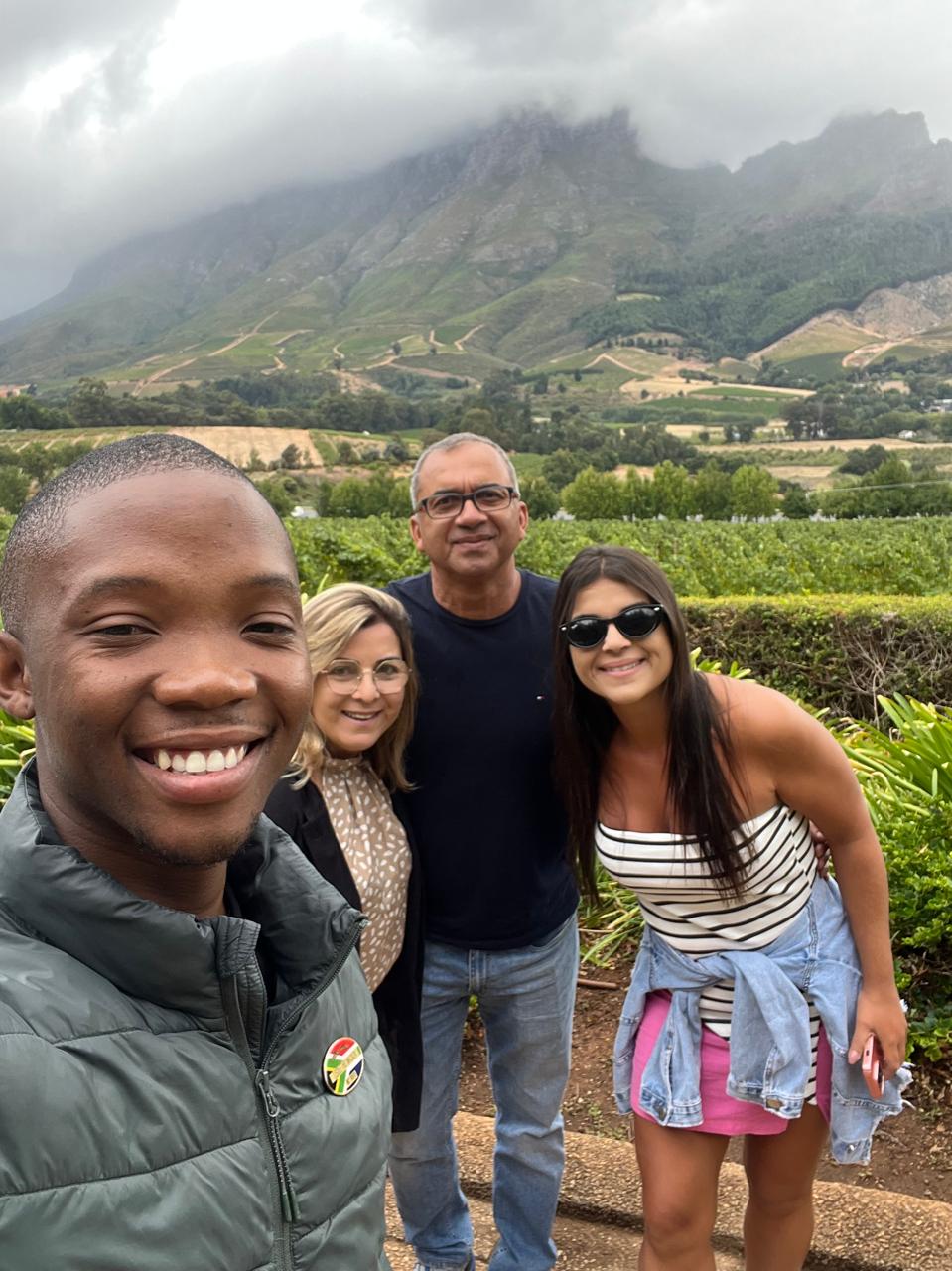 Guide and guests in front of vineyards below the Stellenbosch mountains