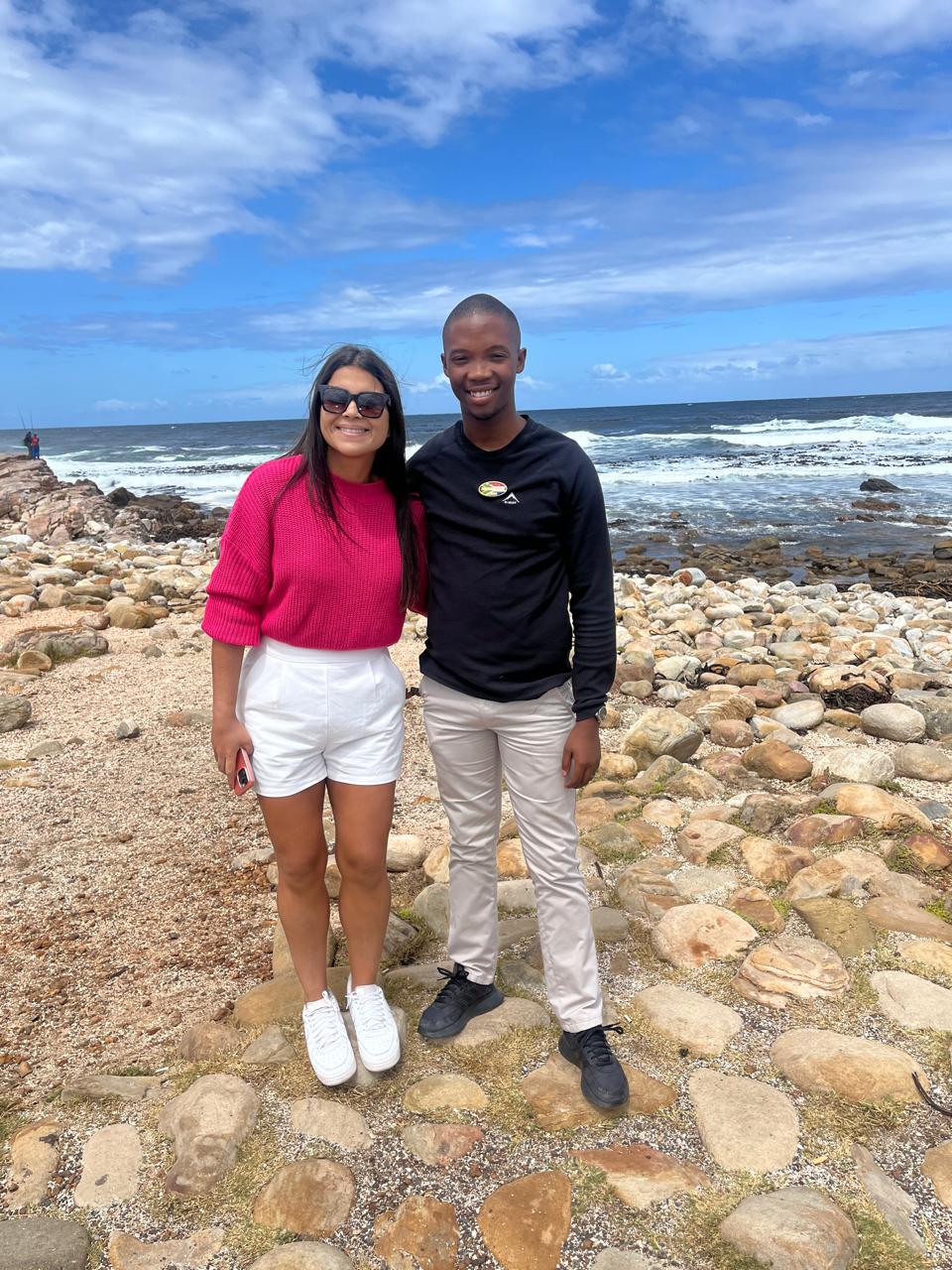 Guide and guest on the rocky shoreline near Cape Point
