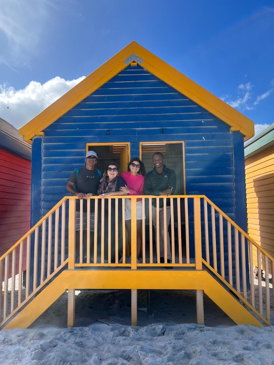 Guide and group at the colorful Muizenberg beach huts