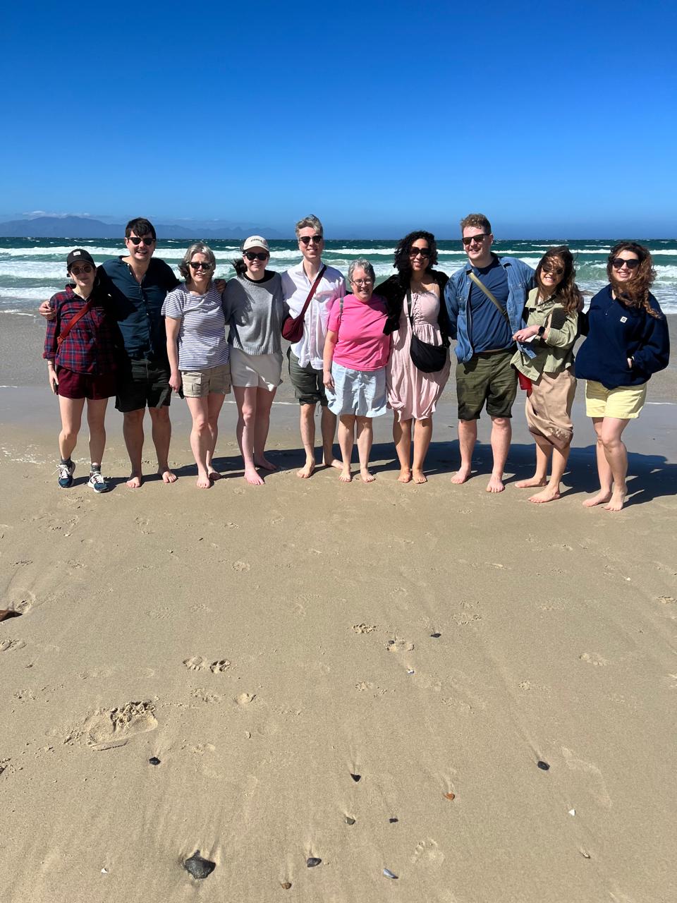 Tour group walking barefoot on a Garden Route beach