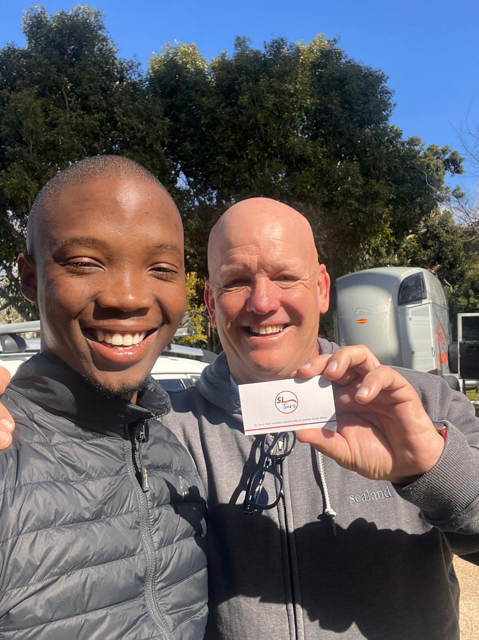 Guide sharing an SL Tours business card with a happy guest