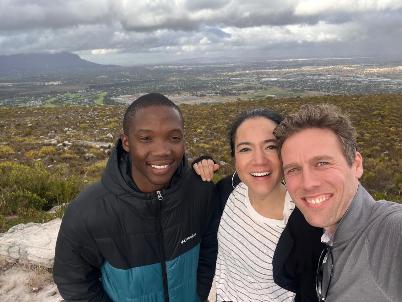Guide and guests atop a mountain overlooking Cape Town's suburbs