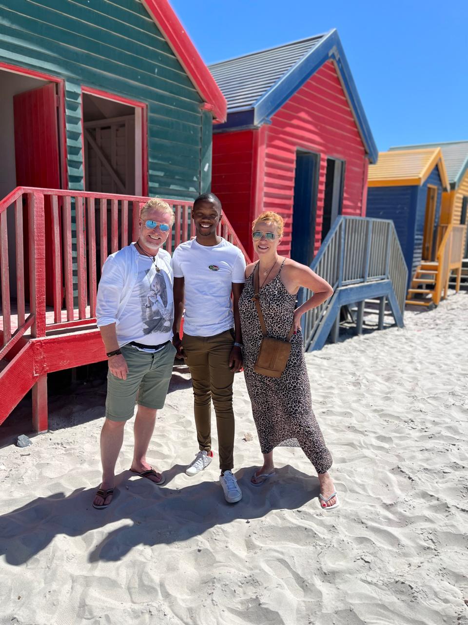 Guide and guest at colorful St James beach huts, Cape Town