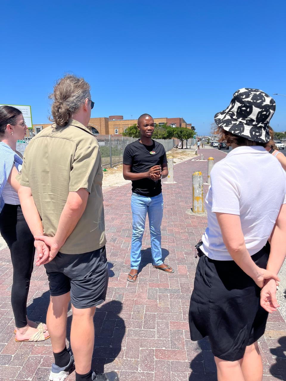 Guide addressing small group on a Khayelitsha township street